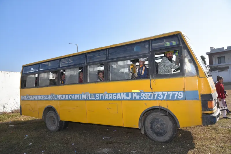 A school bus with the school's name and phone number painted on the side