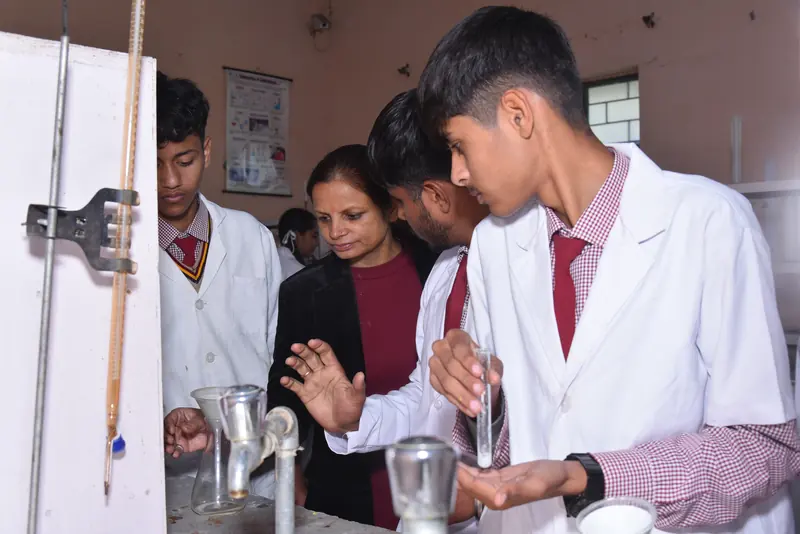 A teacher guiding students through a chemistry practical