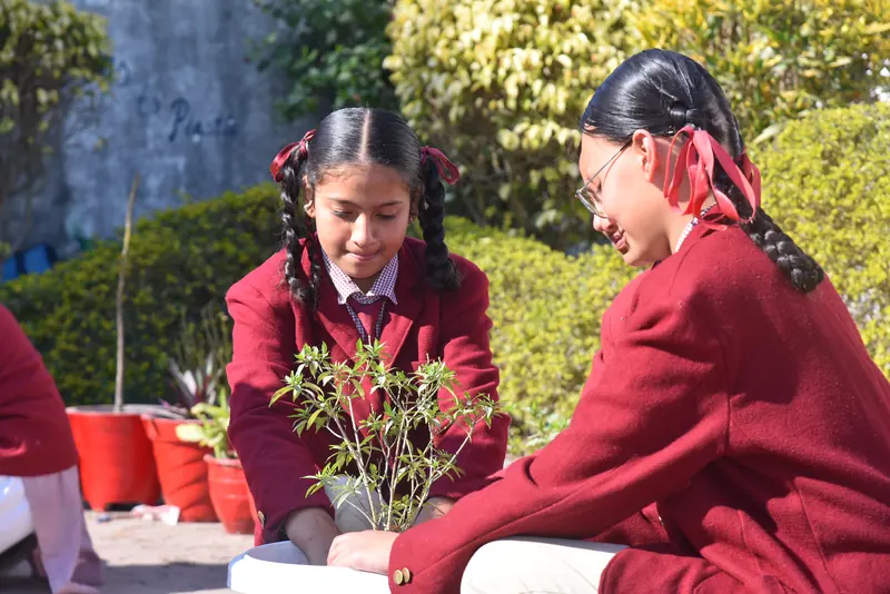 Two students tending a plant