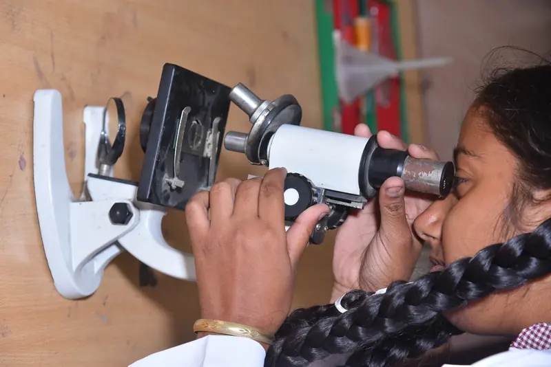 A student looking through a microscope