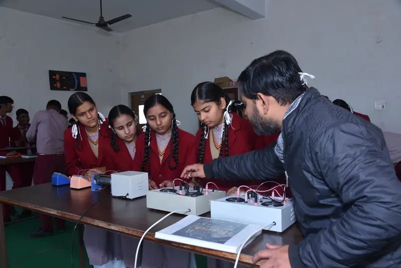 A physics teacher setting up an experiment with students